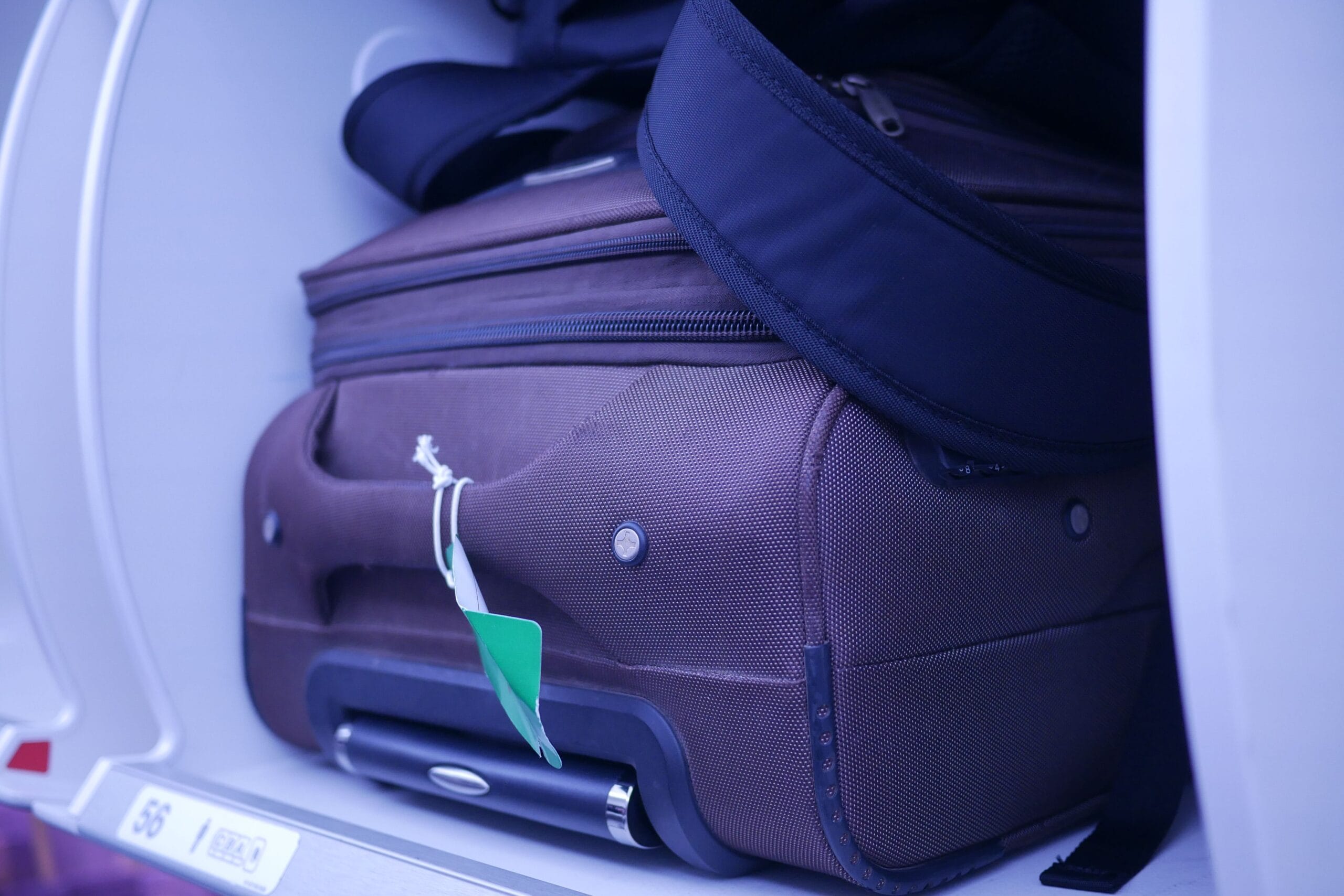 Flying with Sleep Apnoea CPAP Machine Close-up of luggage in an airplane's overhead compartment, showcasing travel essentials.