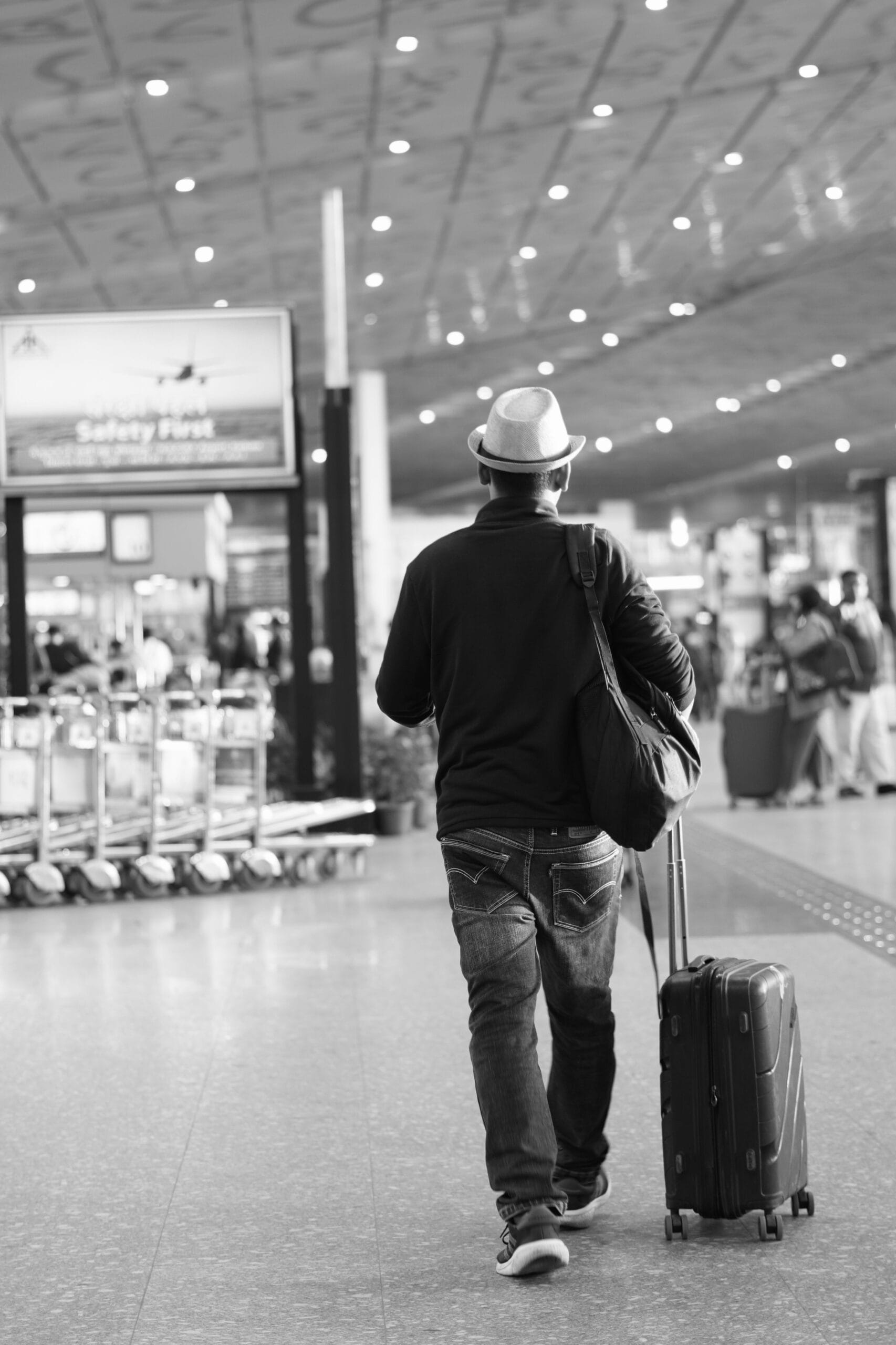 Flying with Epilepsy: A Complete Guide, Back view of a traveler with suitcase in Kolkata airport terminal.